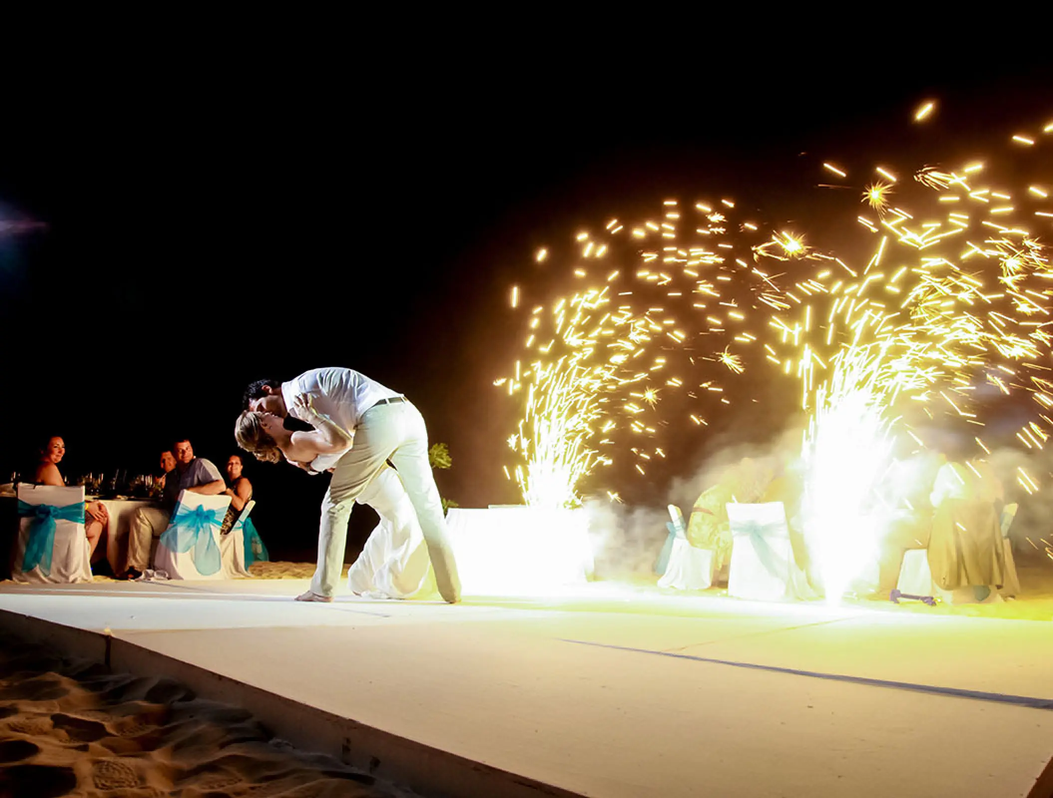 The bride and groom kiss during a first dance with sparklers at Ocean Coral & Turquesa, Riviera Maya