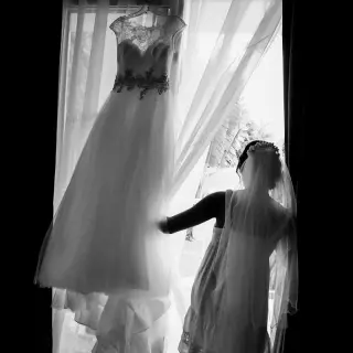 Silhouette of a bride looking at her wedding dress by a window at Ocean Coral & Turquesa, Riviera Maya