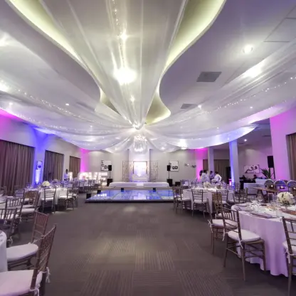 Ballroom wedding reception with white ceiling drapes and a dance floor at Nickelodeon Riviera Maya