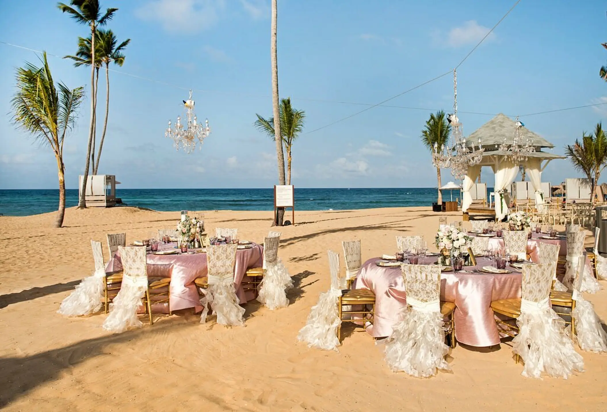 Beachfront wedding reception with pink linens and chandeliers at Nickelodeon Punta Cana