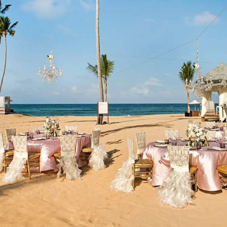 Beachfront wedding reception with pink linens and chandeliers at Nickelodeon Punta Cana
