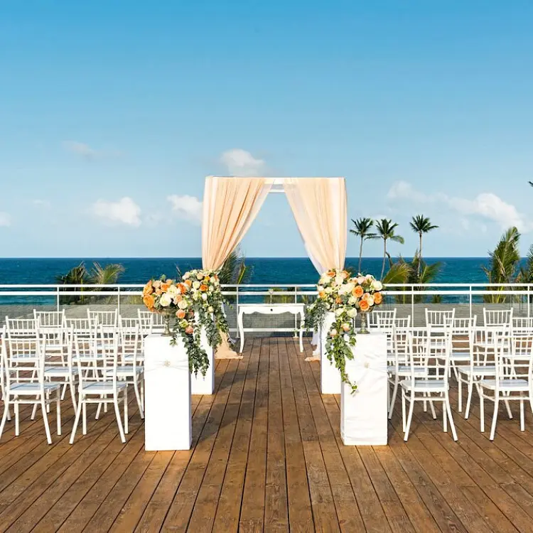 Rooftop wedding ceremony with white chairs and floral arch at Nickelodeon Punta Cana