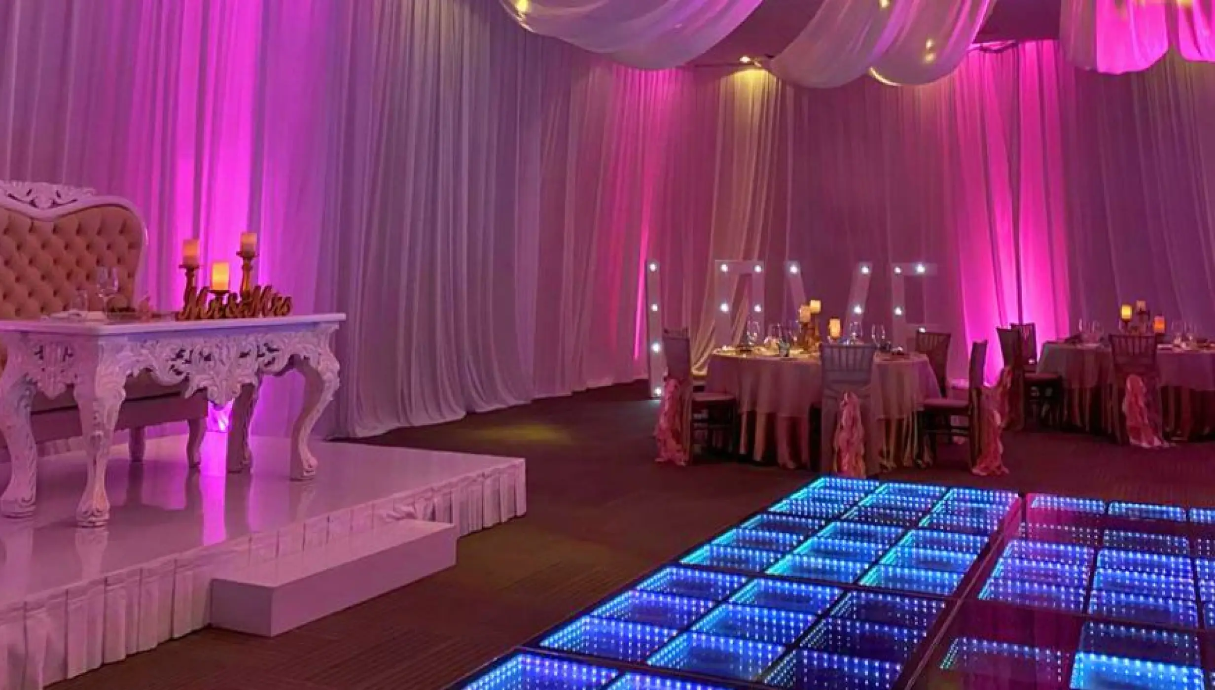 Indoor wedding reception at Nickelodeon Riviera Maya with pink lighting and an LED dance floor