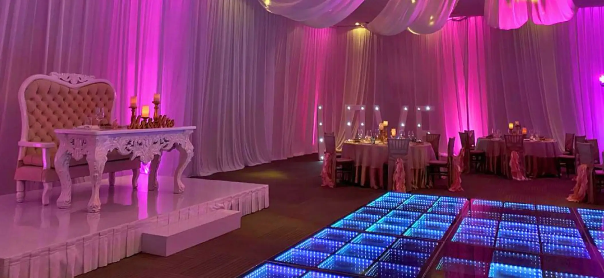 Indoor wedding reception at Nickelodeon Riviera Maya with pink lighting and an LED dance floor