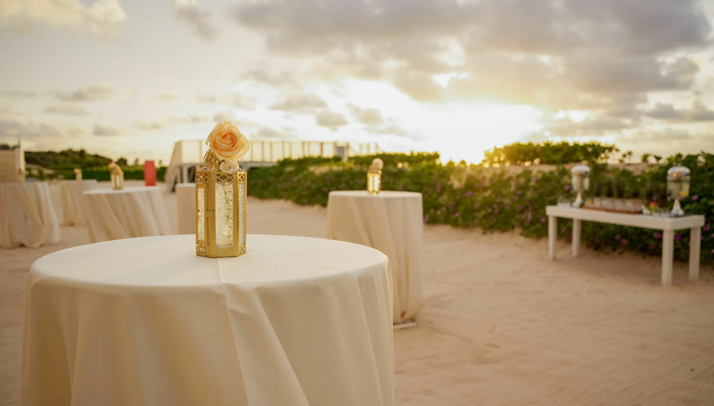 Beachfront wedding reception cocktail tables at sunset, Nickelodeon Riviera Maya