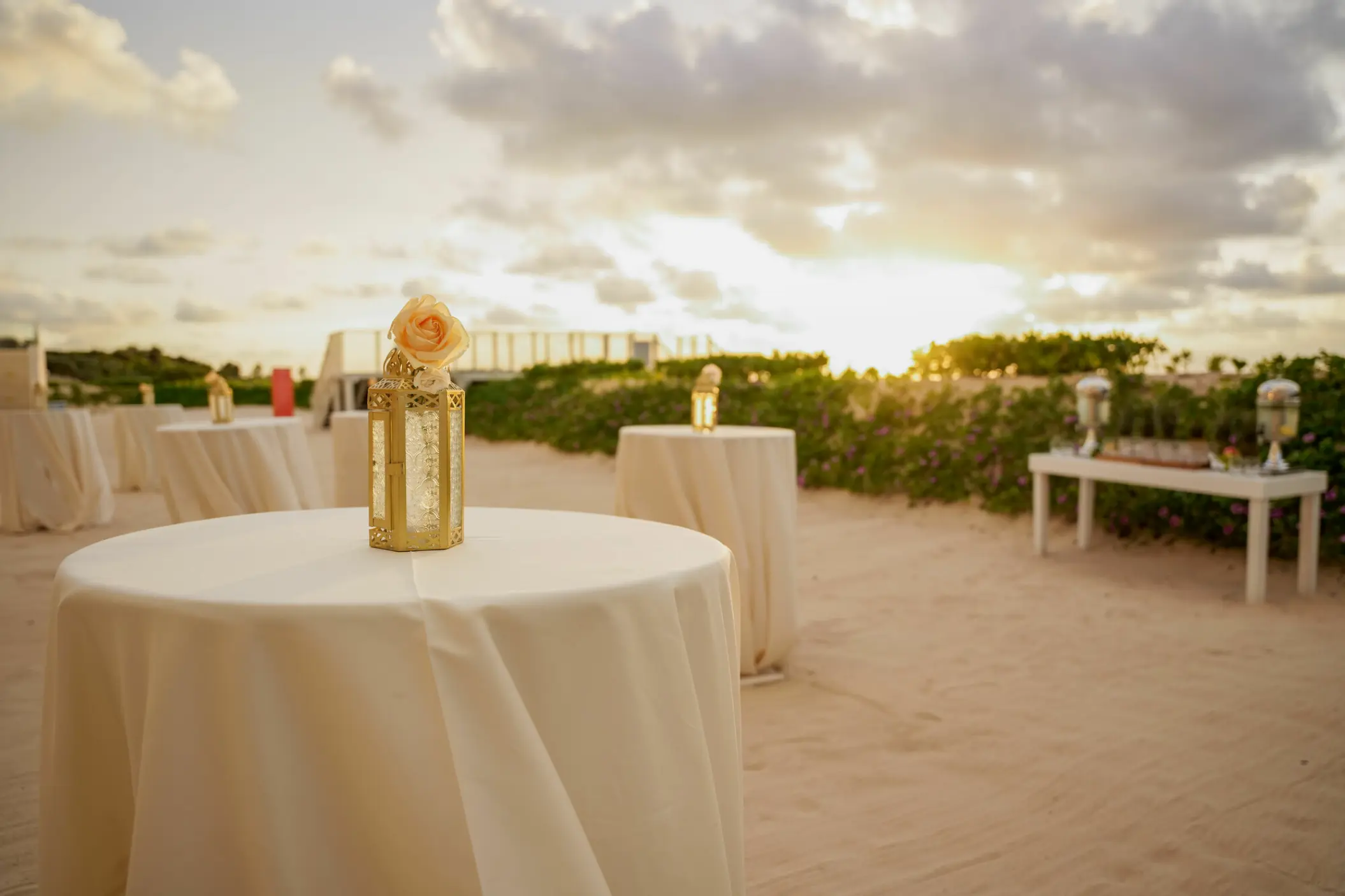 Beachfront wedding reception cocktail tables at sunset, Nickelodeon Riviera Maya