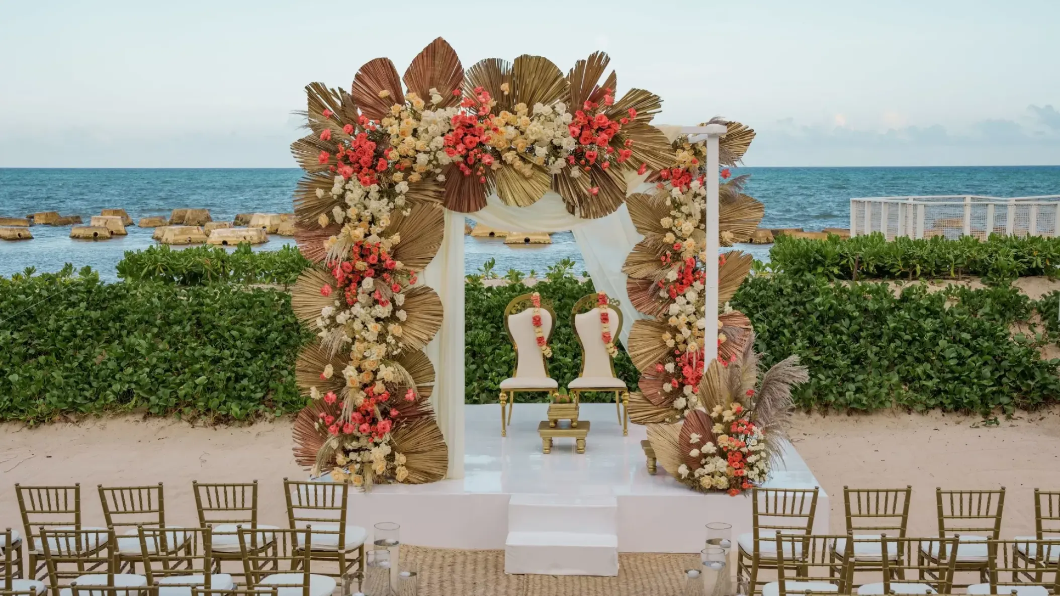Beachfront wedding ceremony with floral arch at Nickelodeon Riviera Maya