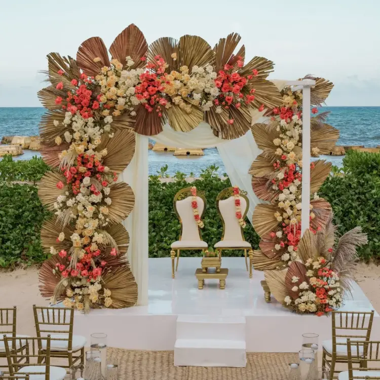 Beachfront wedding ceremony with floral arch at Nickelodeon Riviera Maya