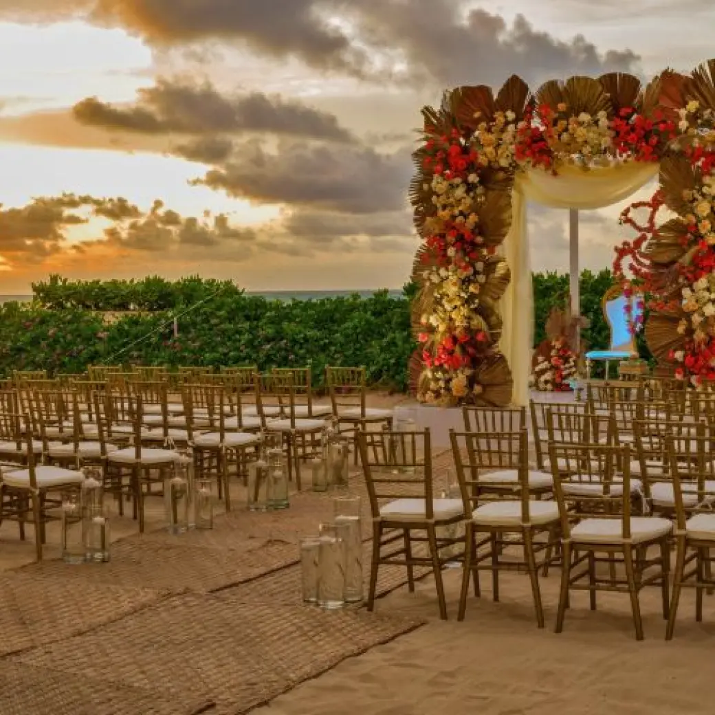 Beachfront wedding ceremony setup with floral arch at Nickelodeon Riviera Maya