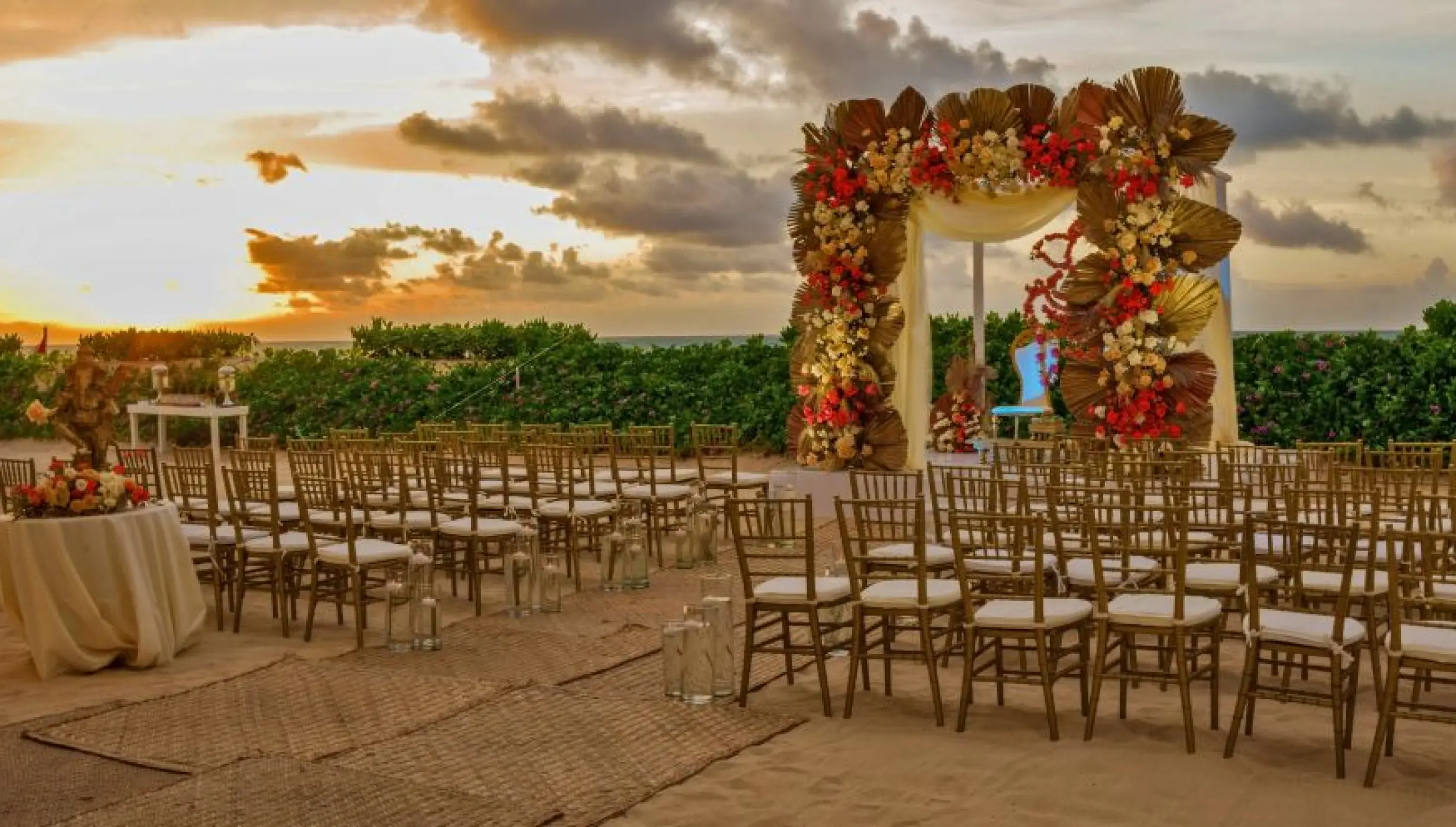 Beachfront wedding ceremony setup with floral arch at Nickelodeon Riviera Maya