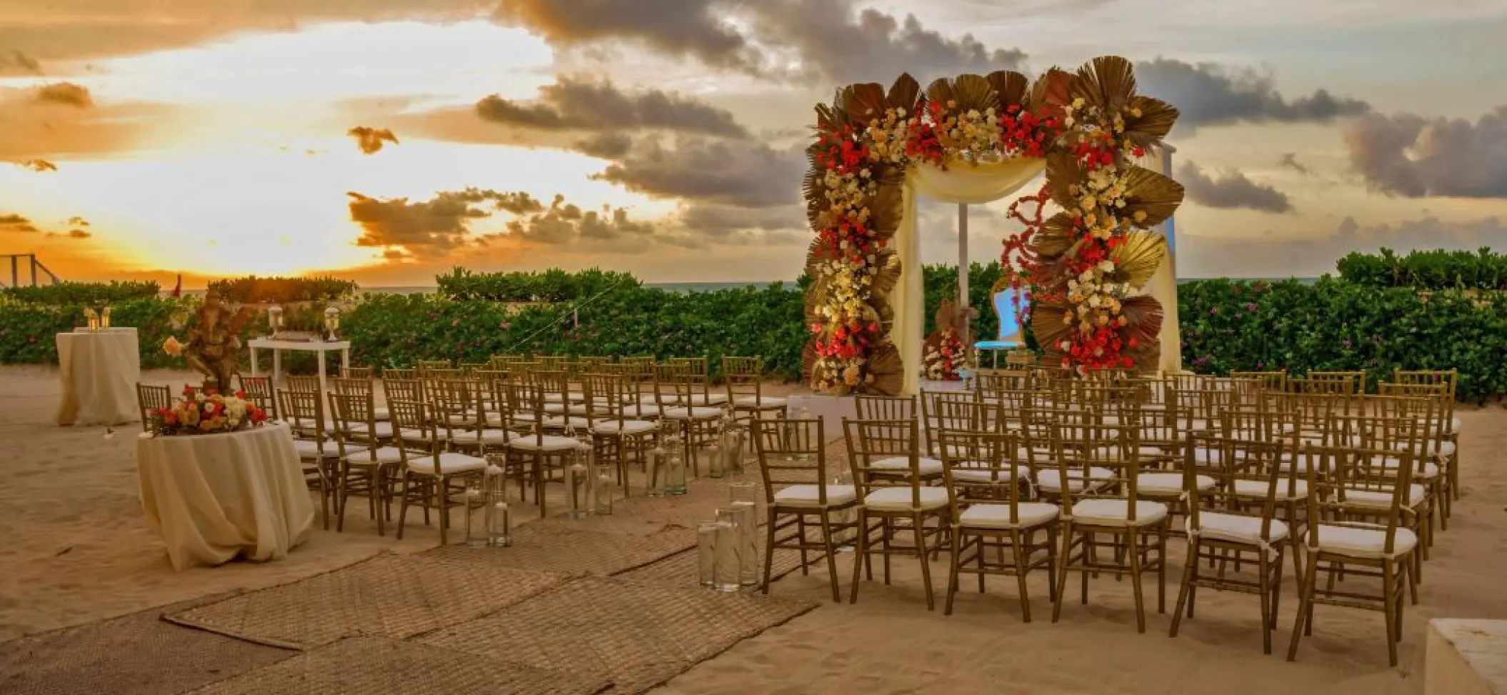 Beachfront wedding ceremony setup with floral arch at Nickelodeon Riviera Maya