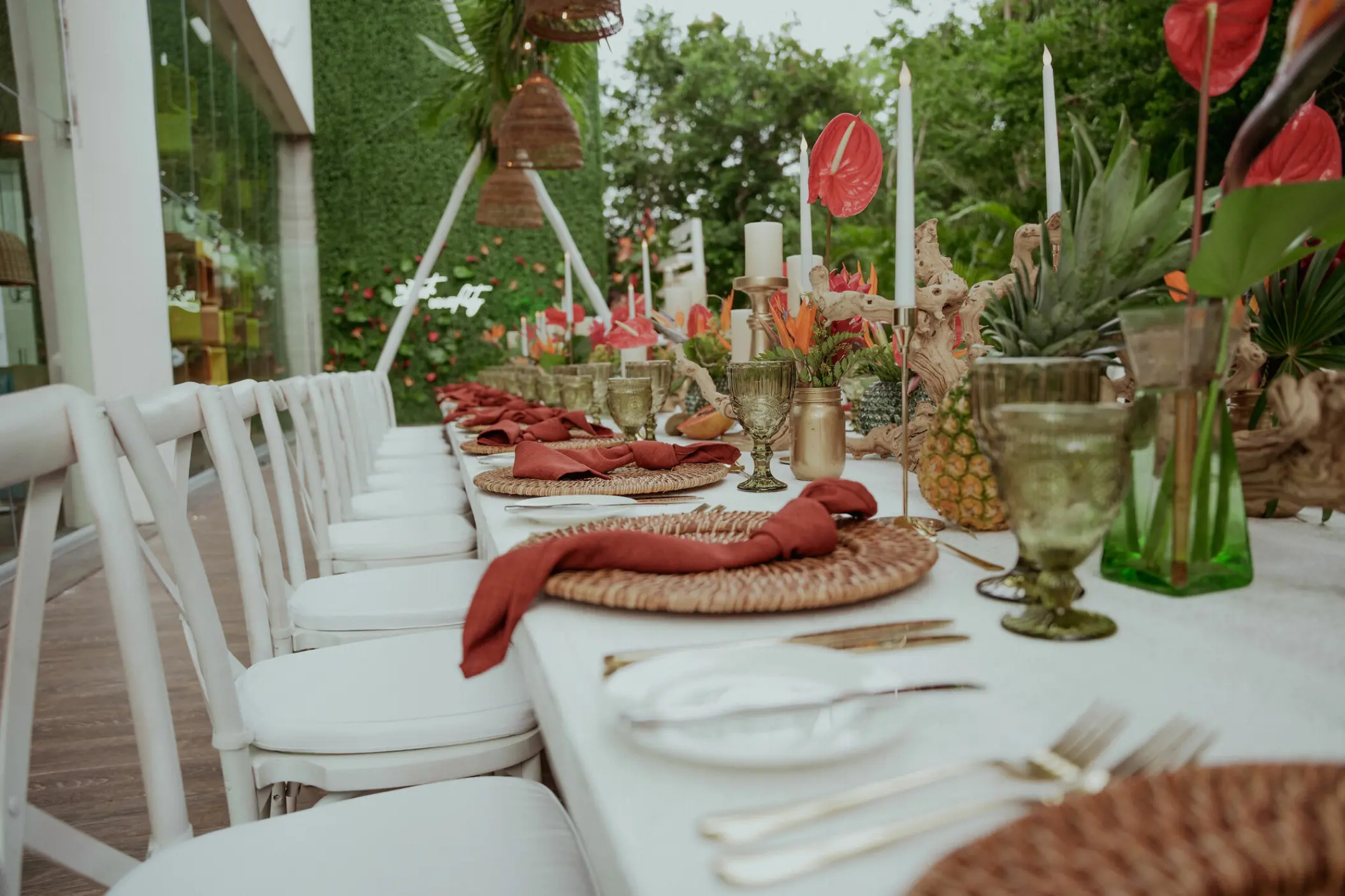 Long wedding reception table with tropical decor and white chairs at Nickelodeon Riviera Maya