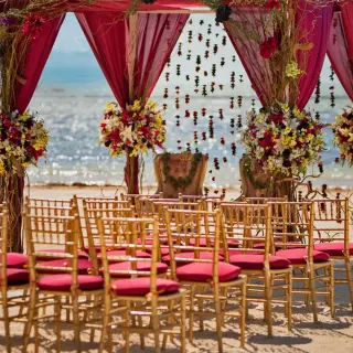 South Asian wedding mandap with pink draping and gold chairs at Nickelodeon Riviera Maya