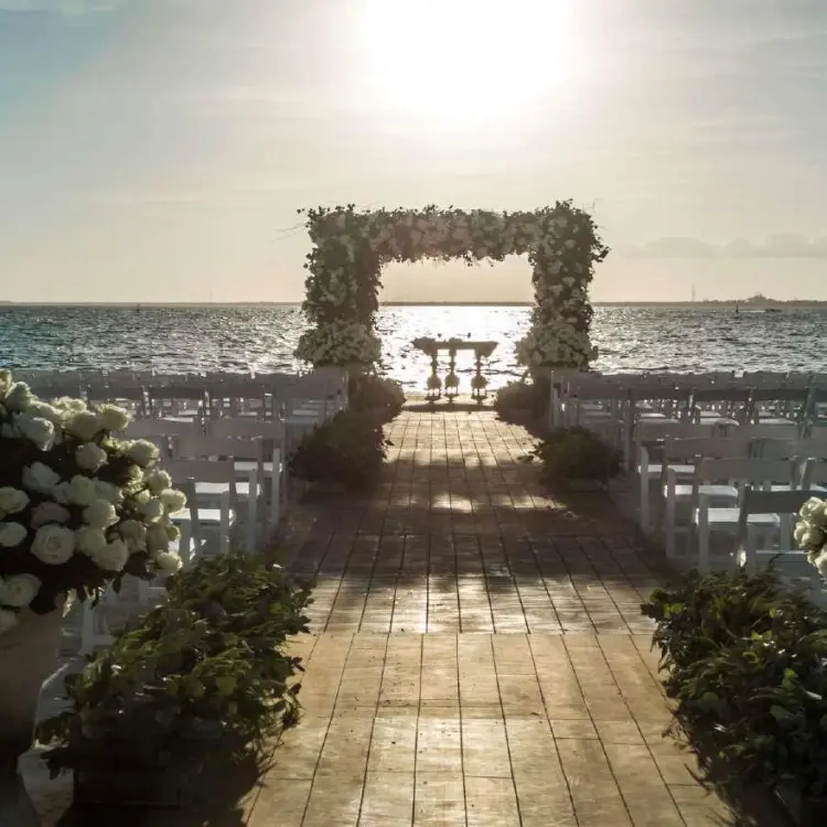 Beachfront wedding ceremony with floral arch at sunset, Nizuc Resort, Cancun