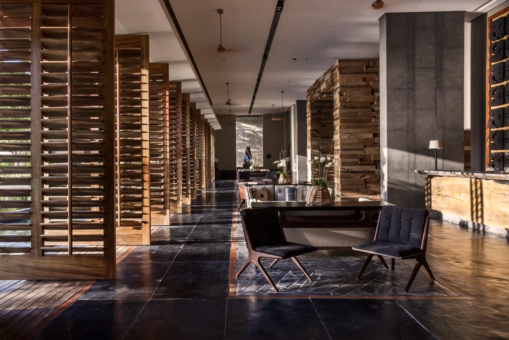 Modern lobby with dark tiled floors and wooden shutters at Nizuc Resort, Cancun