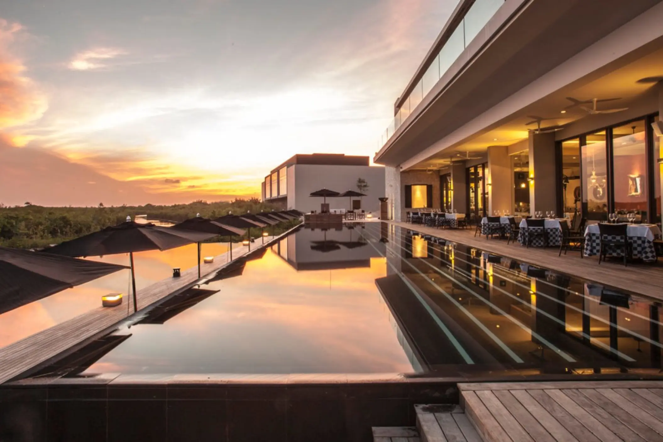 Nizuc Resort infinity pool at sunset with terrace dining, Cancun