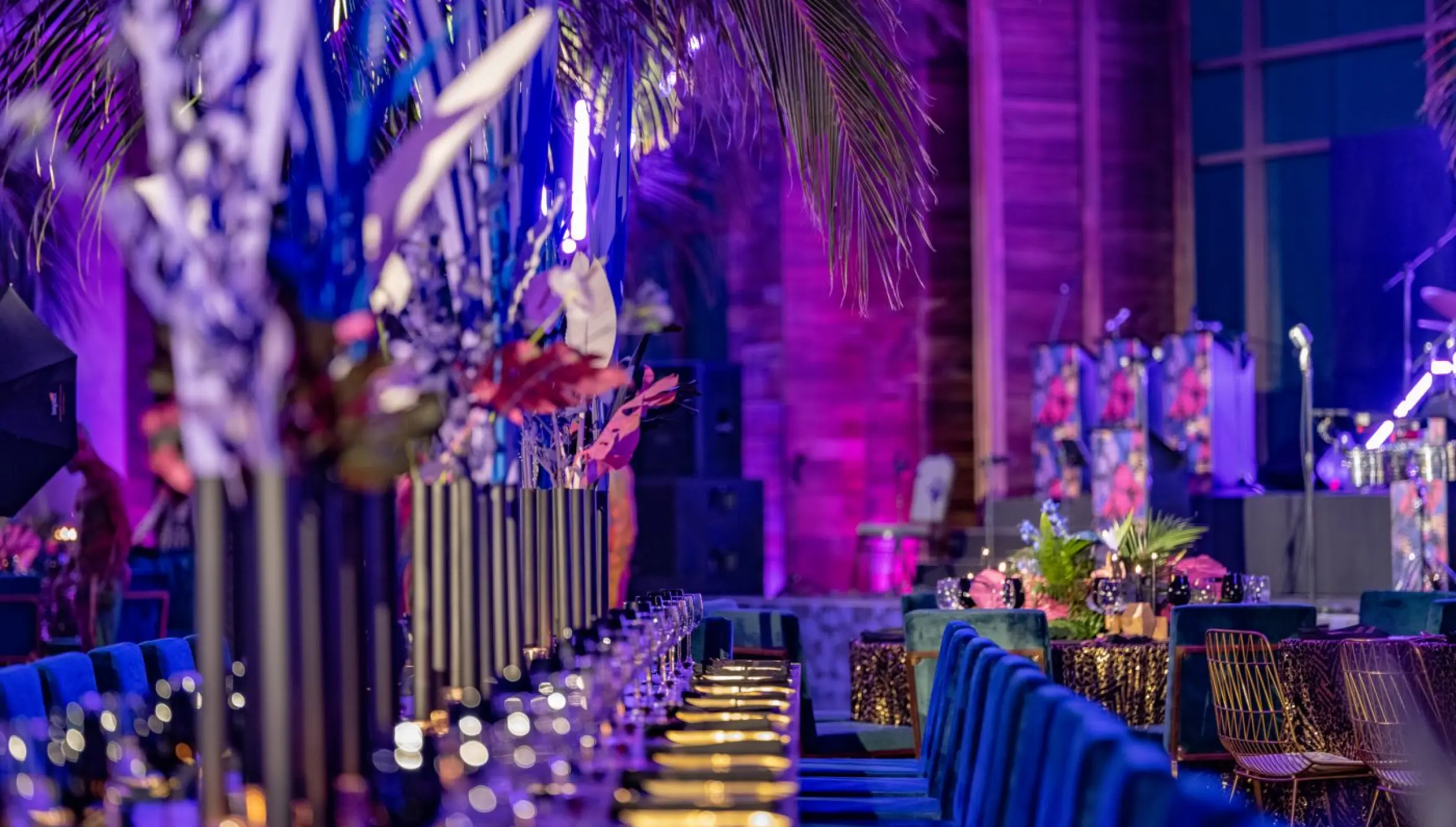 Indoor wedding reception with purple lighting and long tables at Nizuc Resort, Cancun