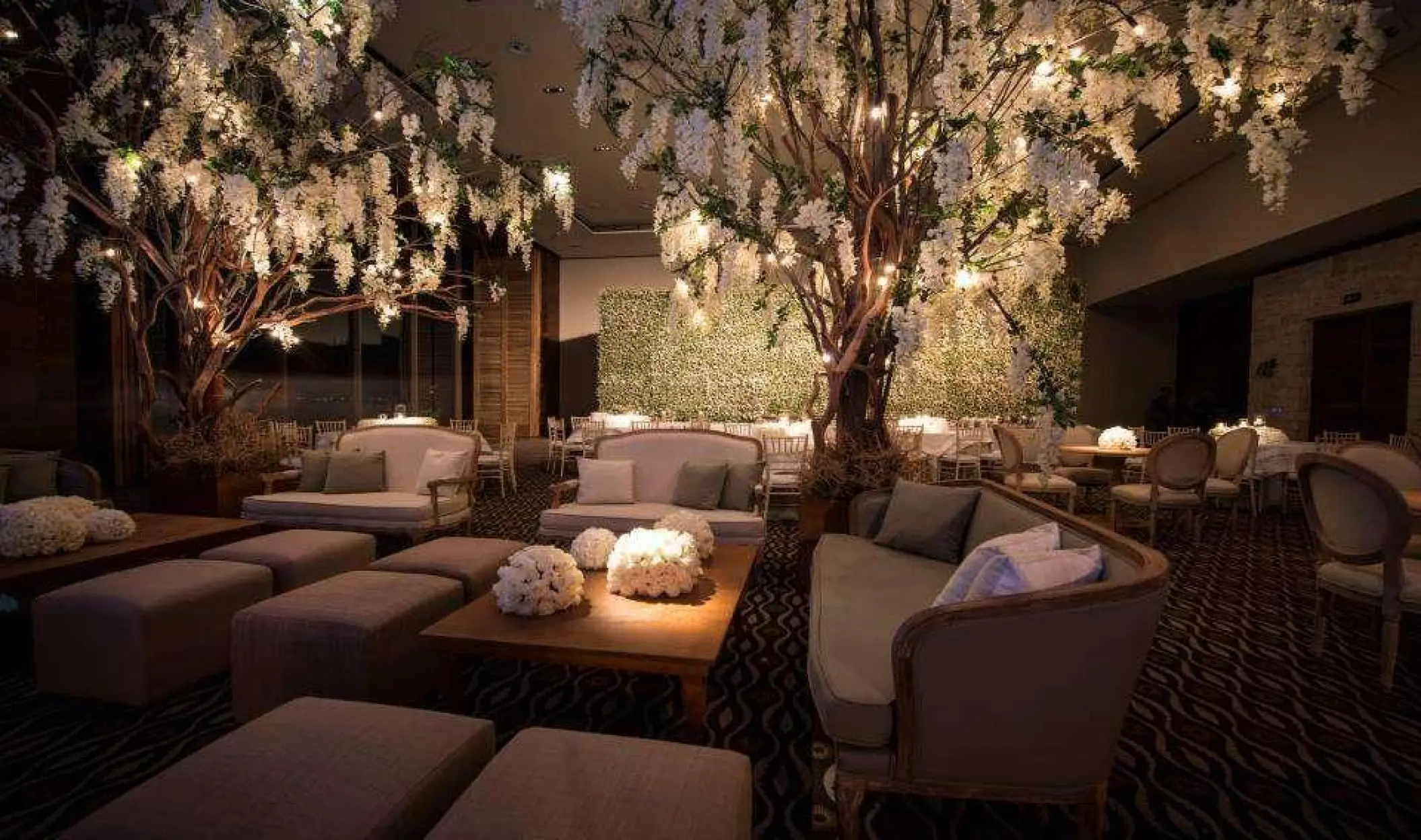 Indoor wedding reception setup with floral trees and lounge seating at Nizuc Resort, Cancun