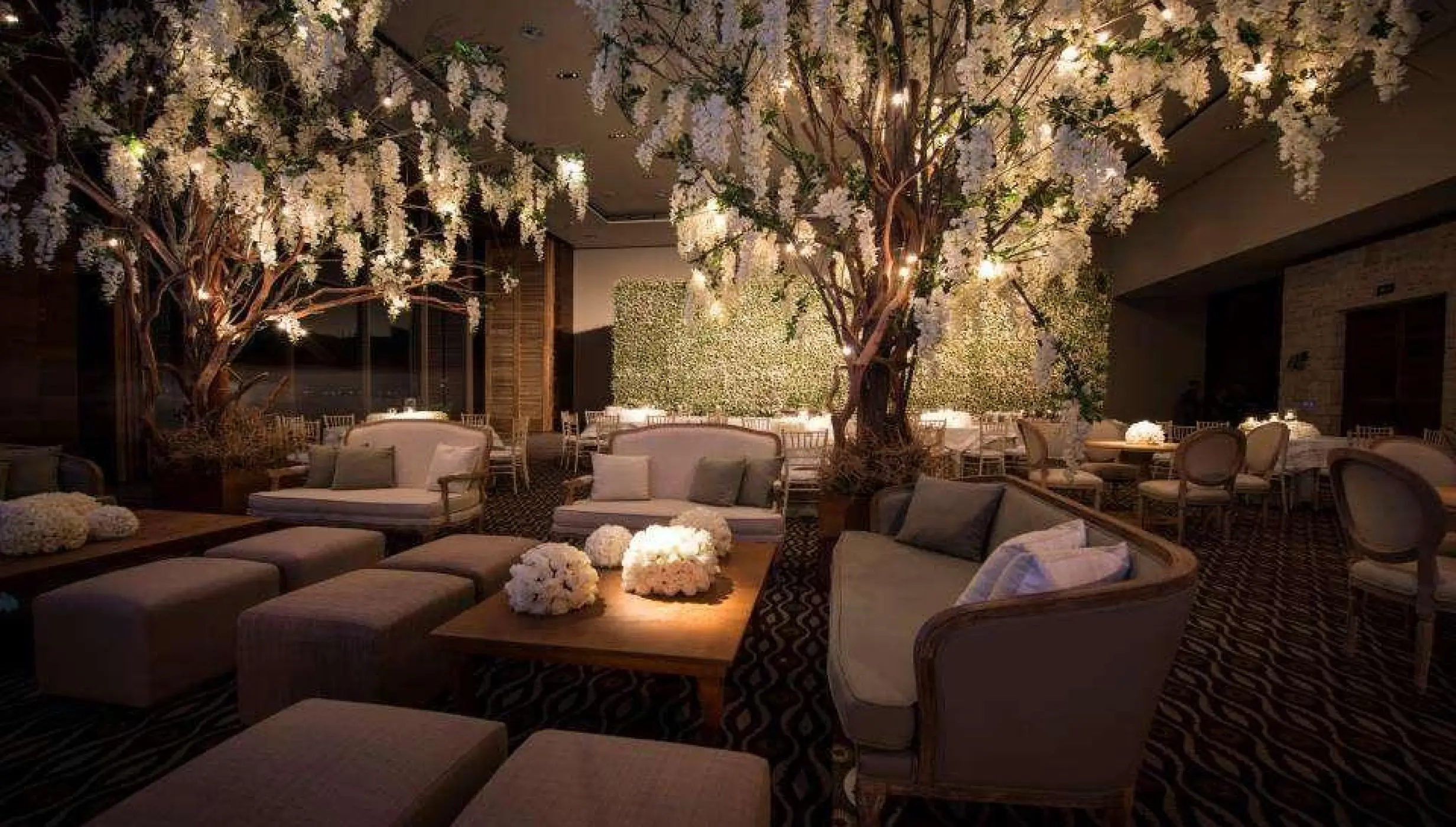 Indoor wedding reception setup with floral trees and lounge seating at Nizuc Resort, Cancun