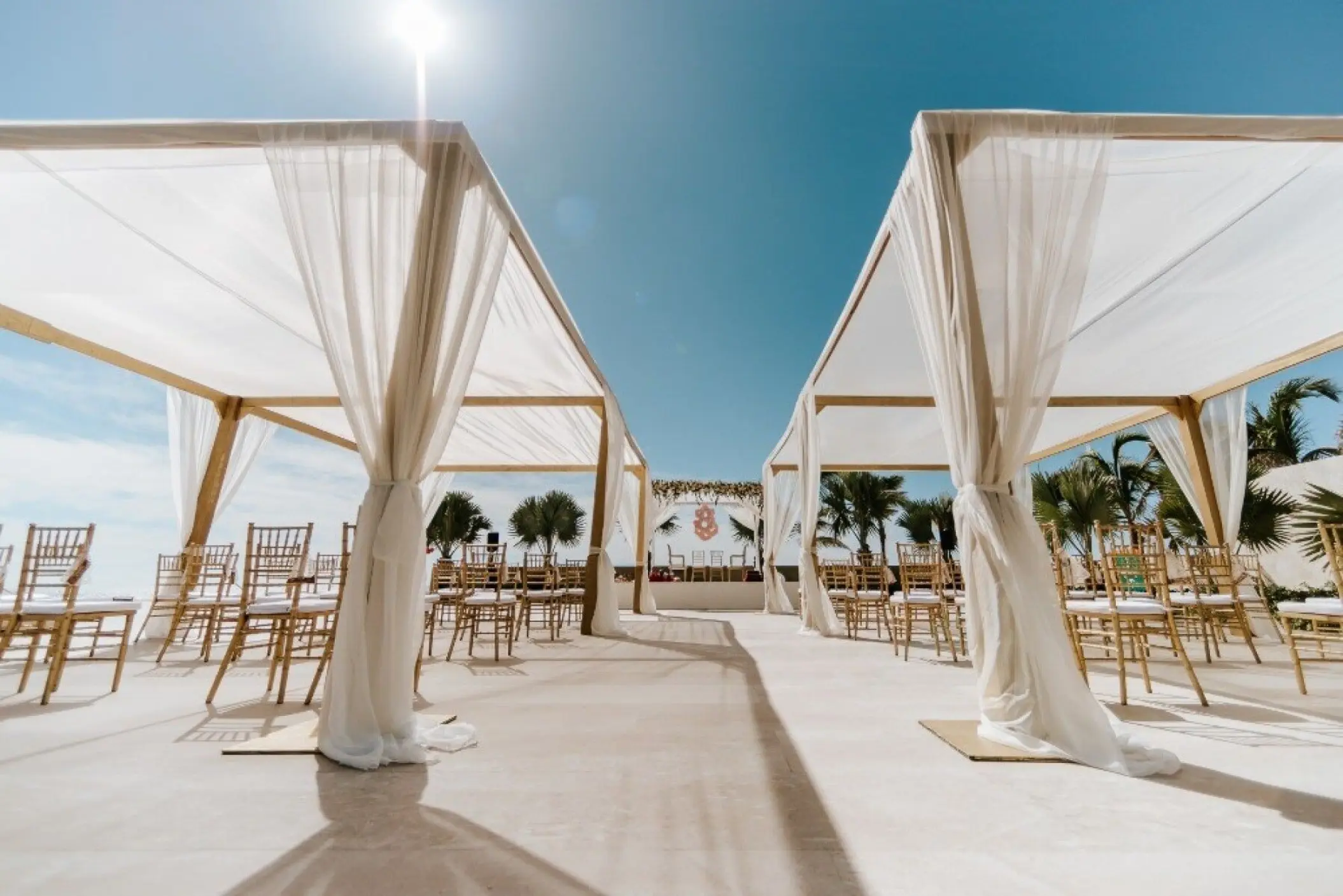 Outdoor wedding ceremony setup under white draped gazebos at Nobu Hotel Los Cabos, Cabo San Lucas