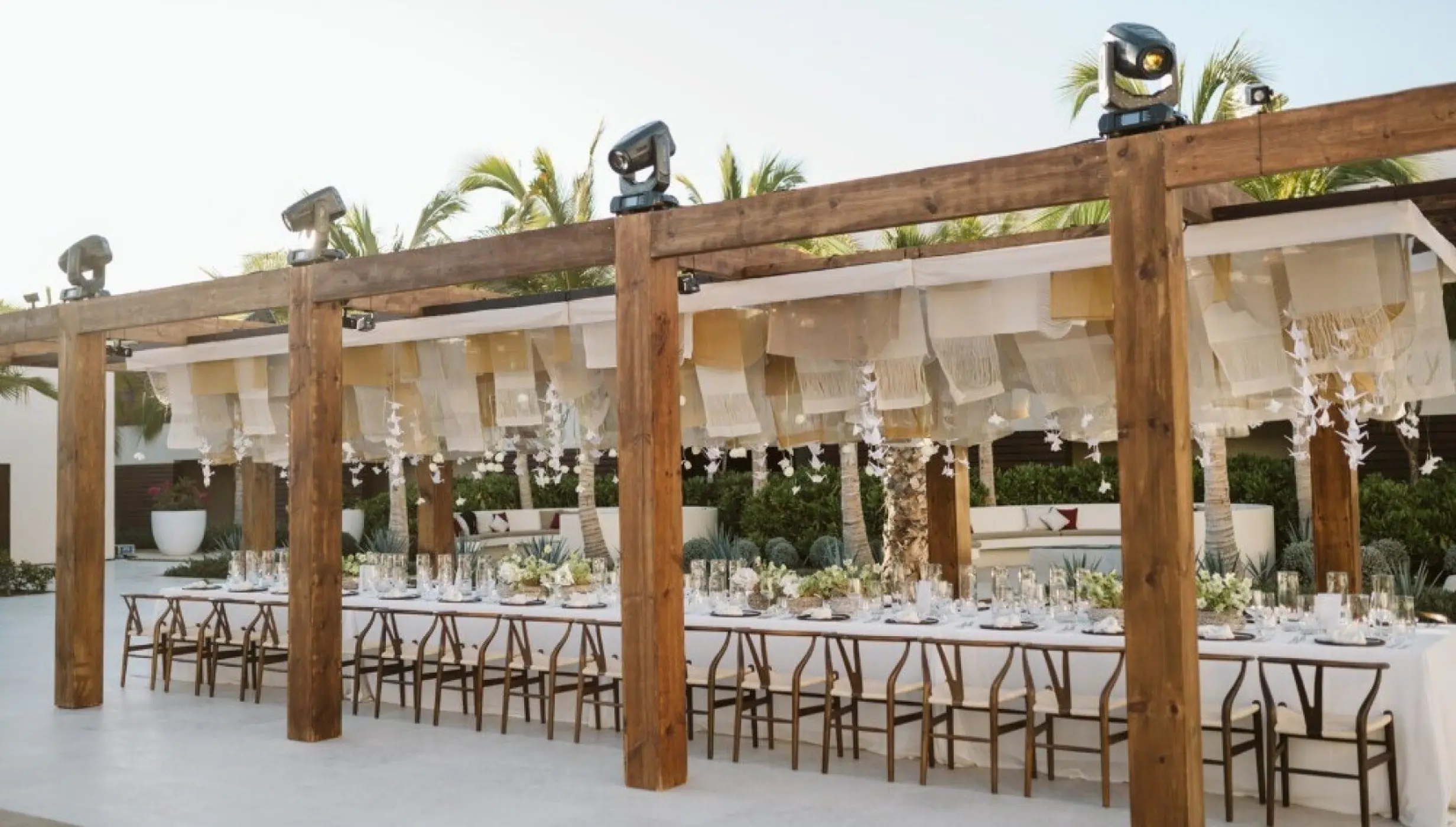 Long banquet table under a wooden pergola at Nobu Los Cabos, Cabo San Lucas