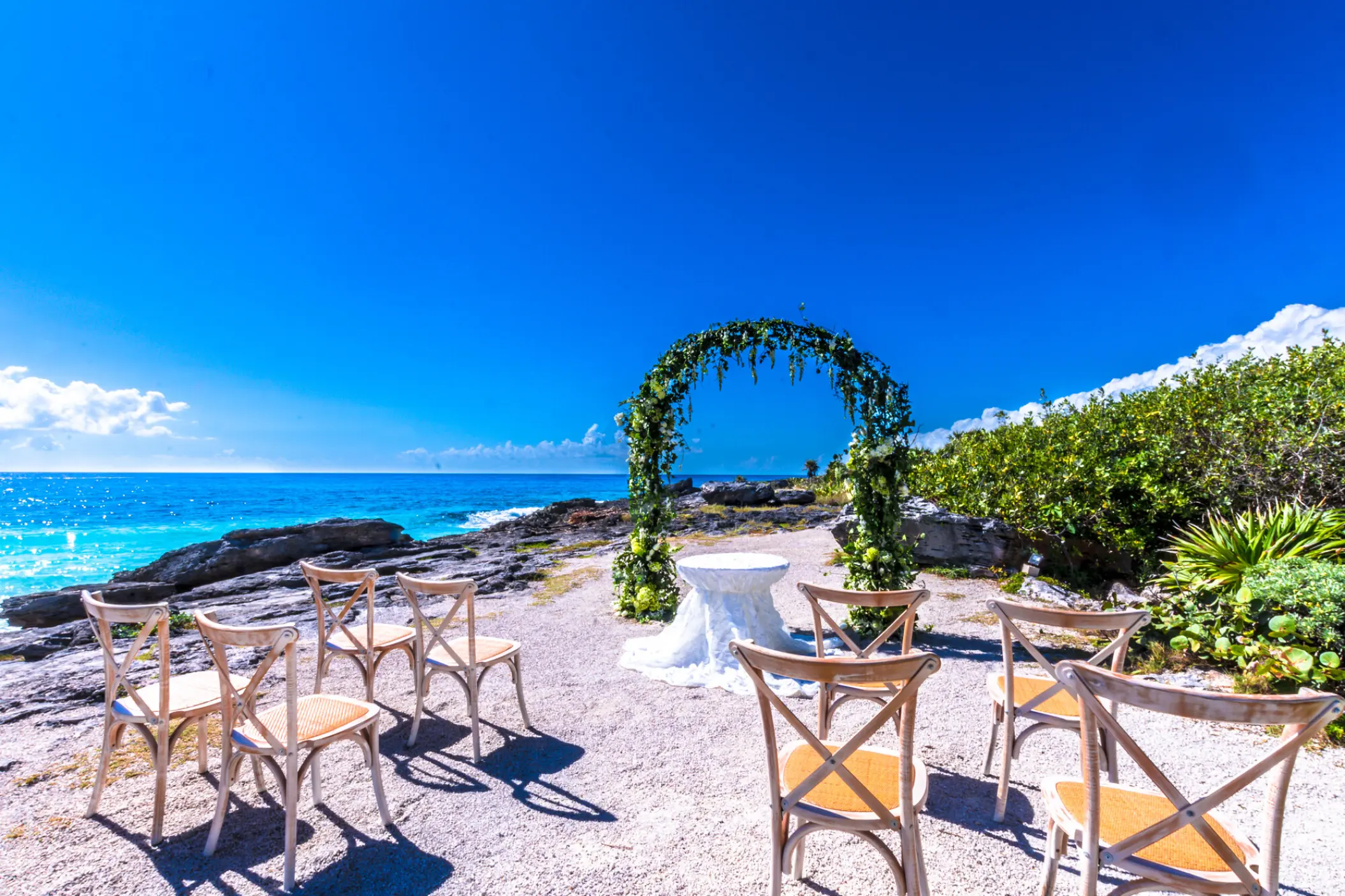Floral arch at a cliffside wedding ceremony at Occidental at Xcaret, Playa Del Carmen