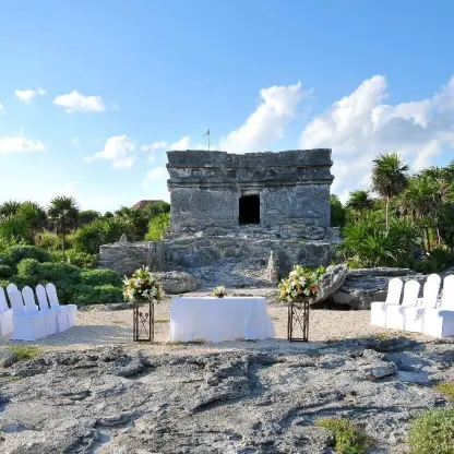 Ruina Maya wedding ceremony with white chairs at Occidental at Xcaret, Playa Del Carmen