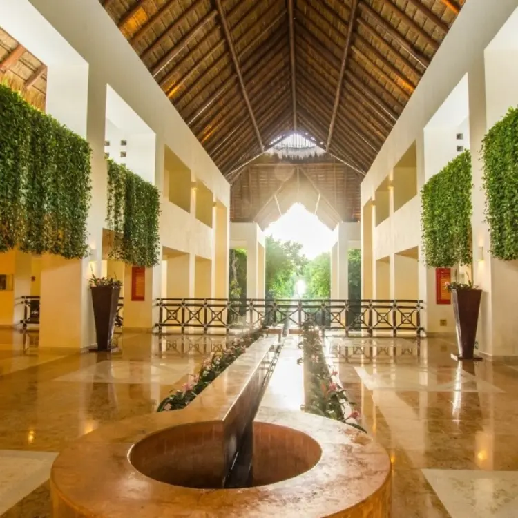 Open-air lobby with vaulted palapa roof and hanging greenery at Occidental at Xcaret, Playa Del Carmen