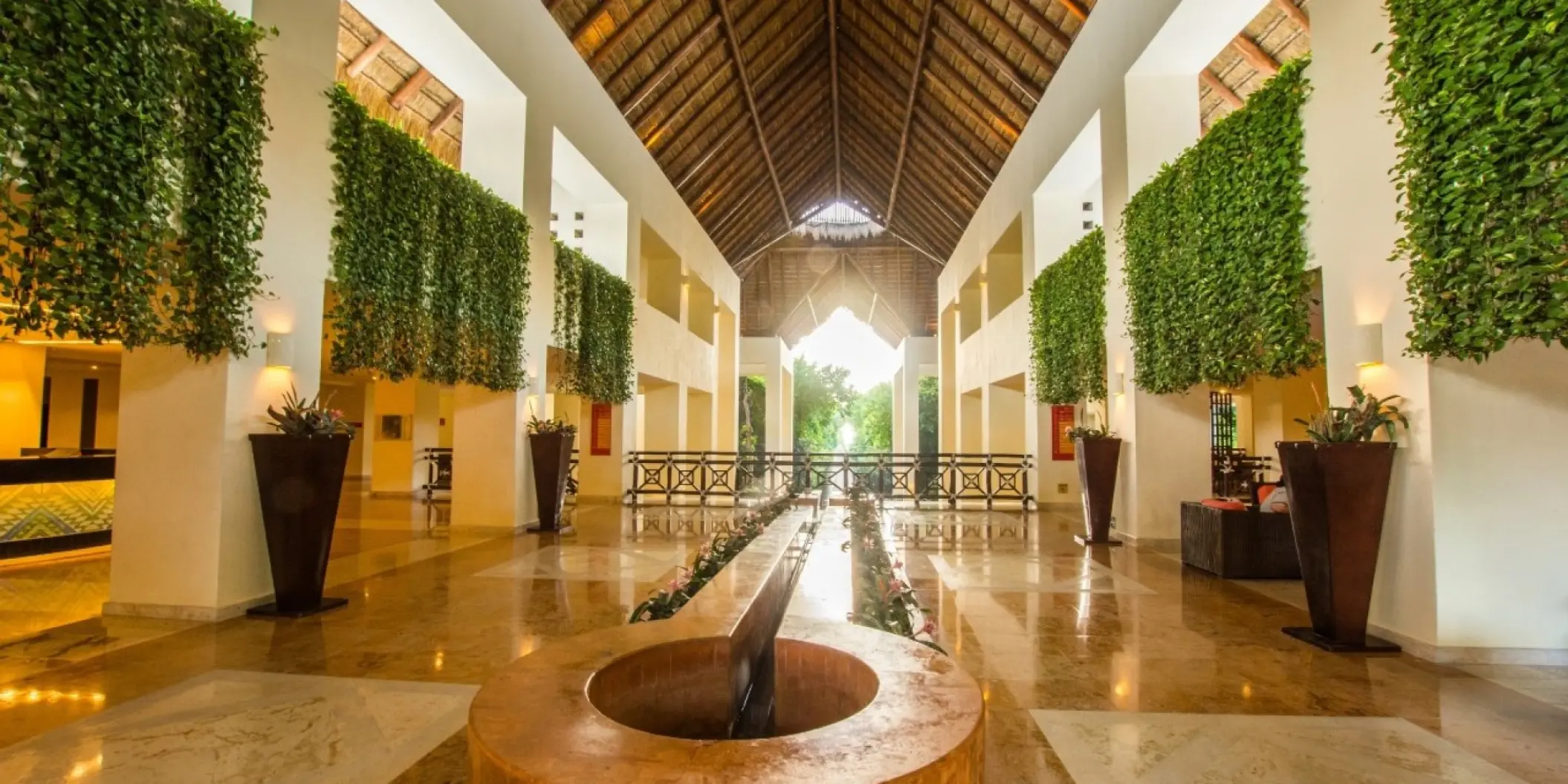 Open-air lobby with vaulted palapa roof and hanging greenery at Occidental at Xcaret, Playa Del Carmen