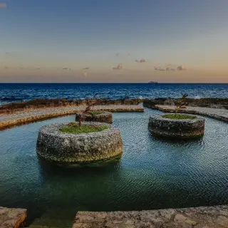 Natural saltwater pool with stone planters at Occidental Xcaret, Playa Del Carmen