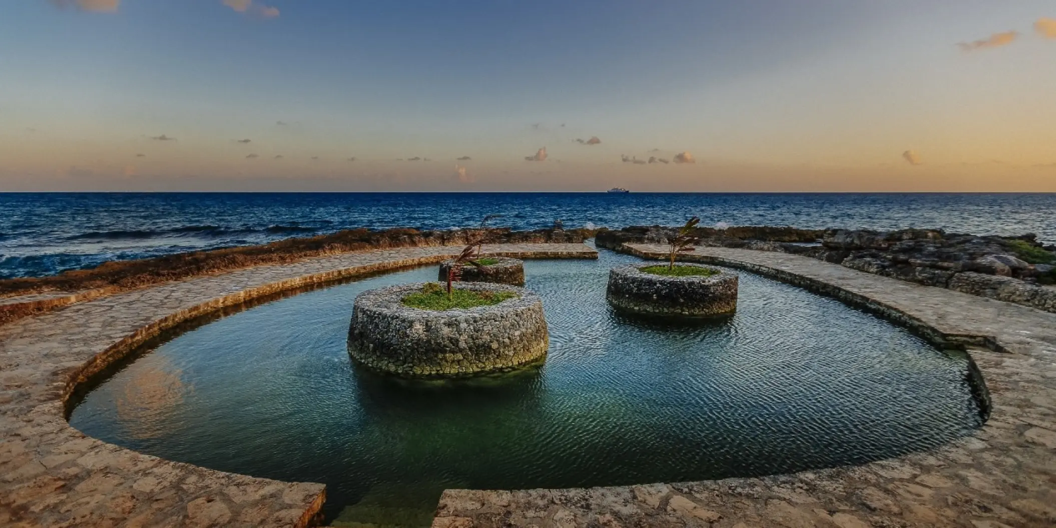 Natural saltwater pool with stone planters at Occidental Xcaret, Playa Del Carmen