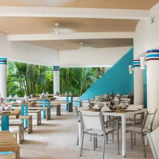 Outdoor restaurant with white and blue accents at Occidental at Xcaret Destination, Playa Del Carmen