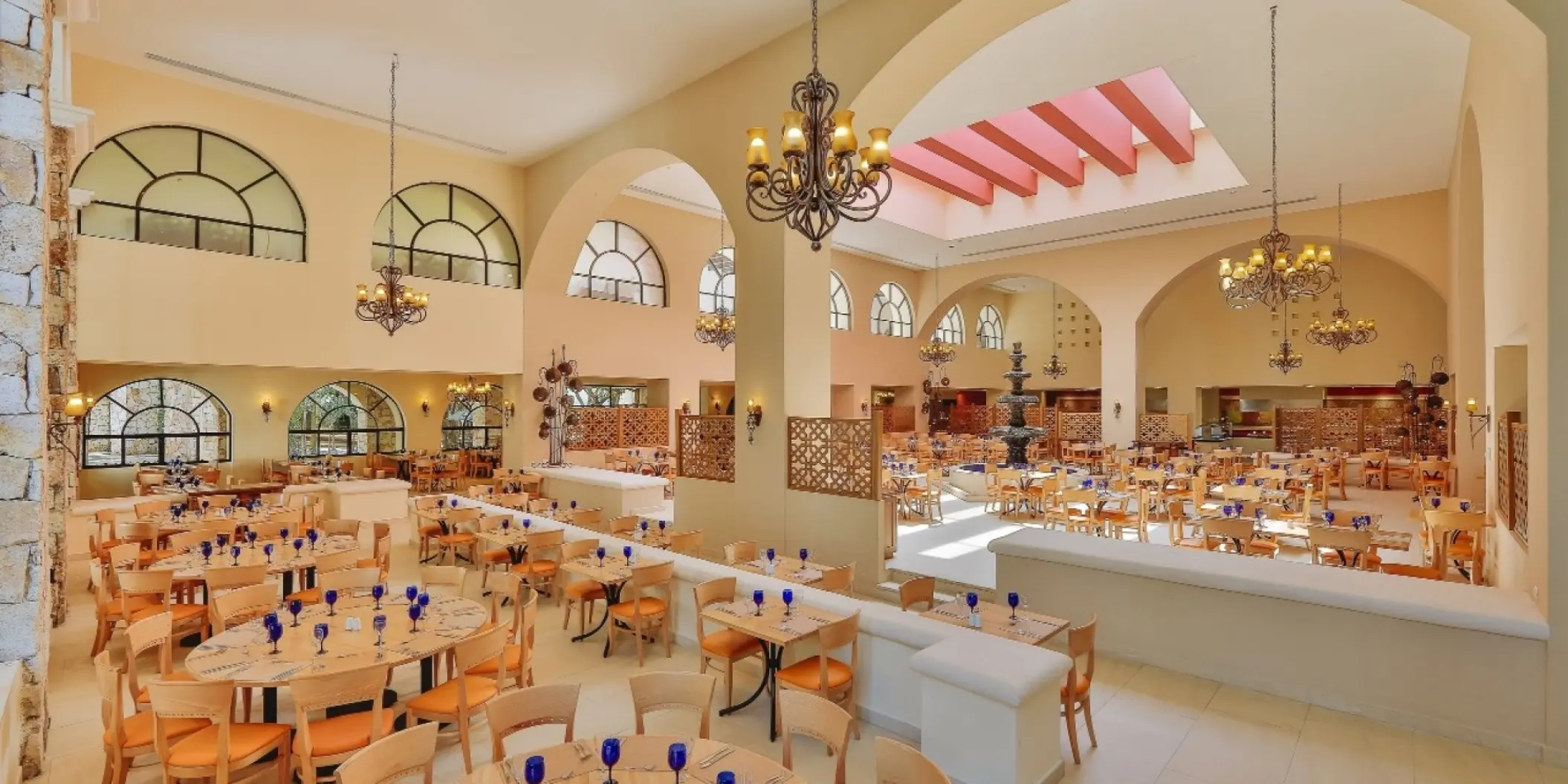 Indoor restaurant dining area with chandeliers and arched ceilings at Occidental at Xcaret, Playa Del Carmen