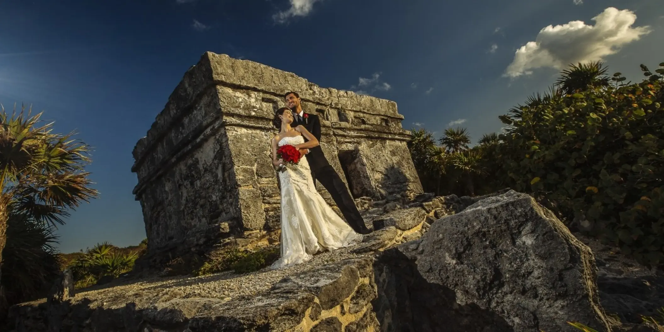 Bride and groom posing by Mayan ruins at Occidental at Xcaret, Playa Del Carmen