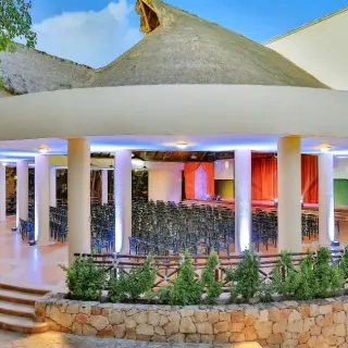 Circular outdoor theater under a thatched roof with blue lighting at Occidental at Xcaret, Playa Del Carmen