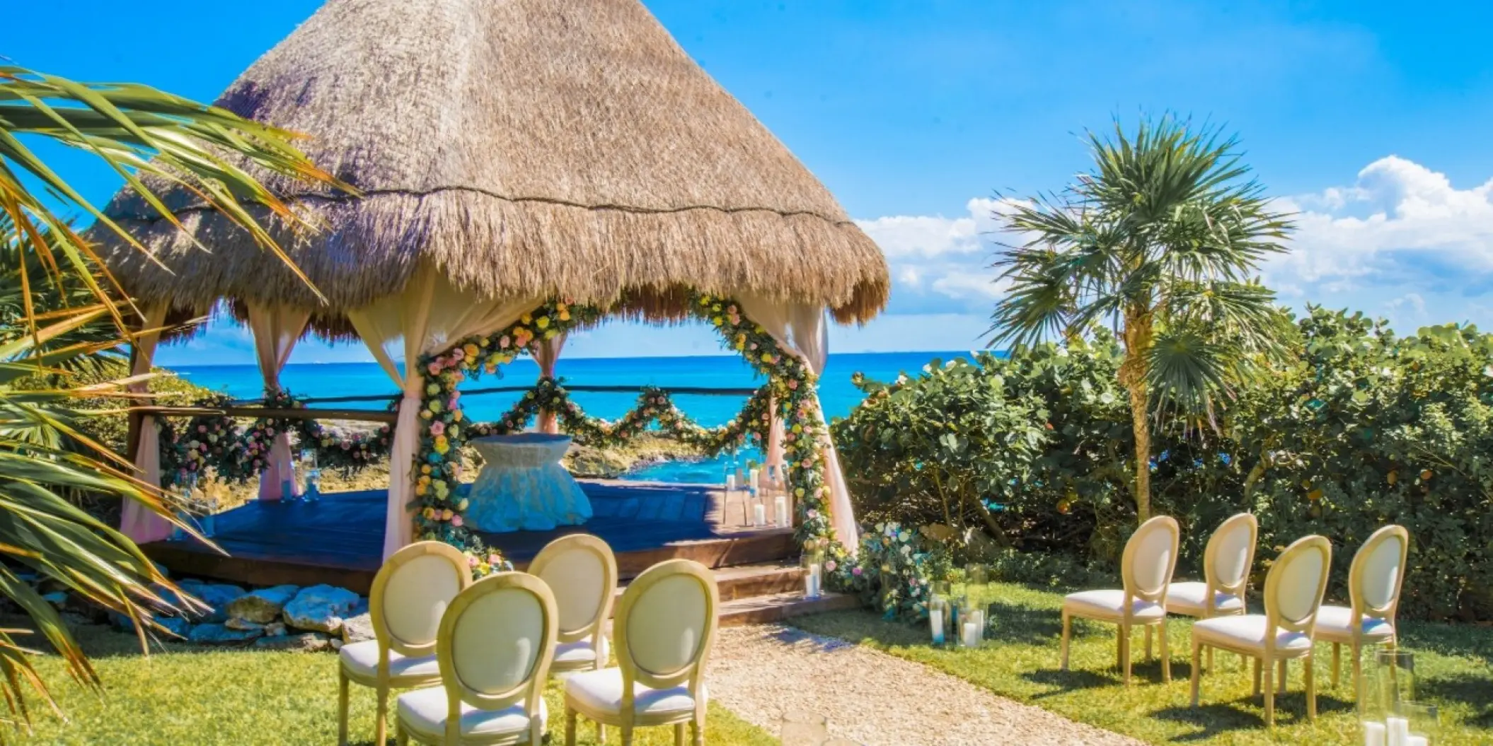 Thatched roof wedding gazebo with floral garlands at Occidental at Xcaret, Playa Del Carmen