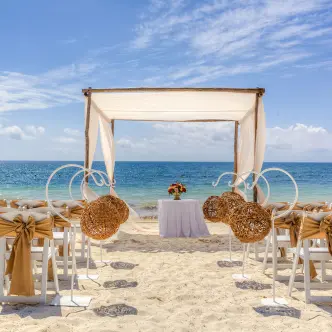 Beachfront wedding ceremony setup with a white huppah at Ocean Coral & Turquesa, Riviera Maya