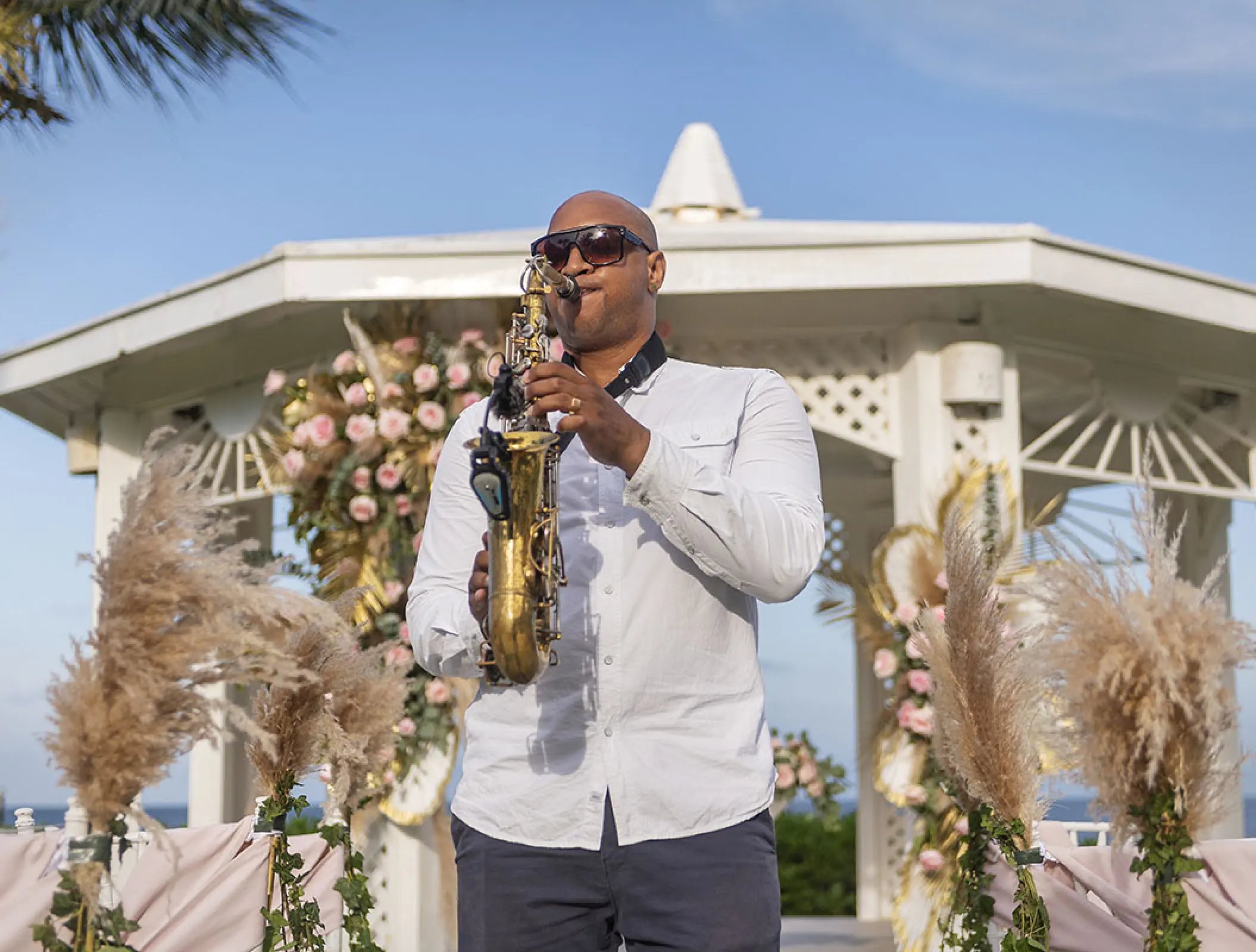A saxophonist performing at an outdoor wedding ceremony at Ocean Coral & Turquesa, Riviera Maya