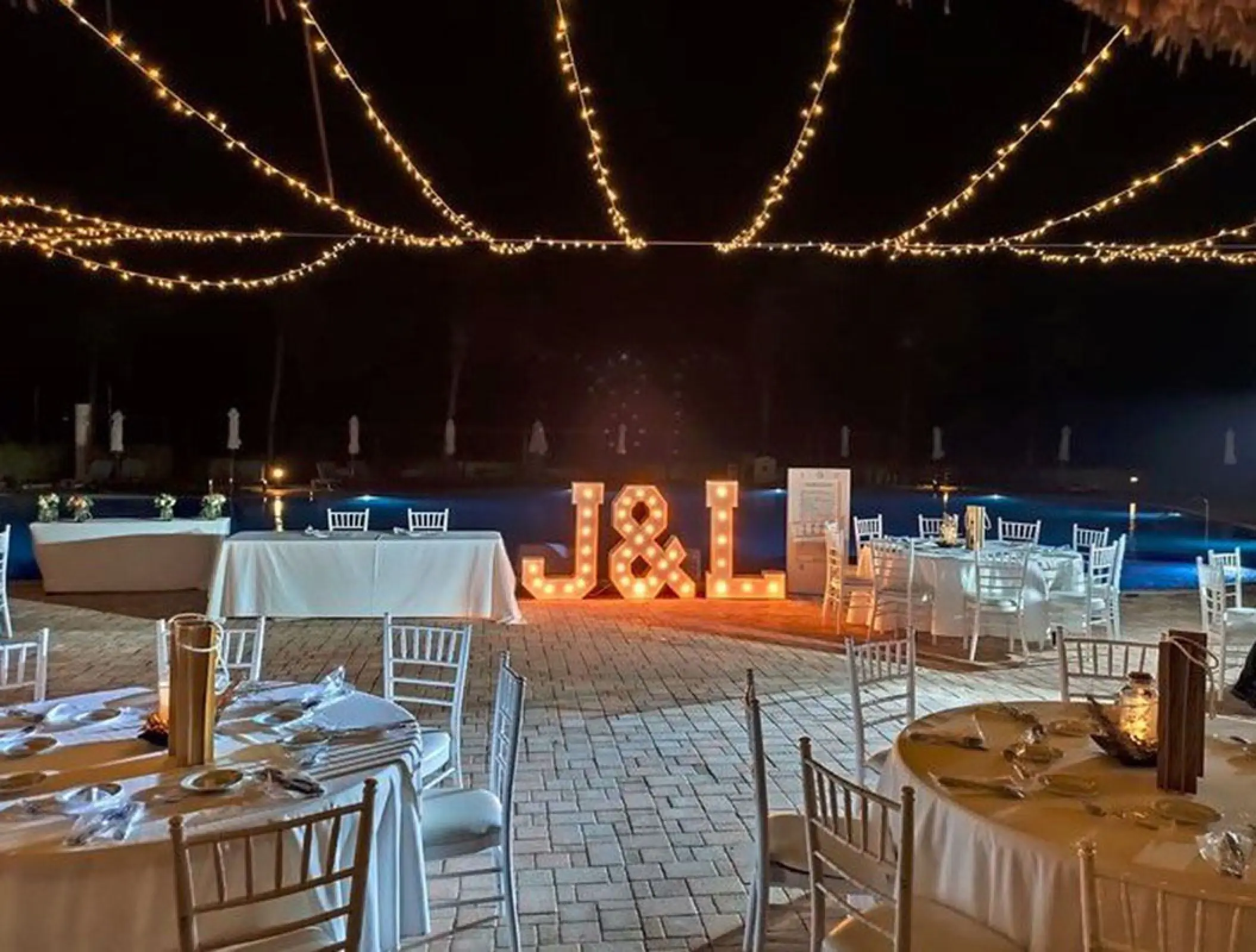 Nighttime terrace wedding reception with marquee letters and string lights at H10 Ocean Coral & Turquesa, Riviera Maya