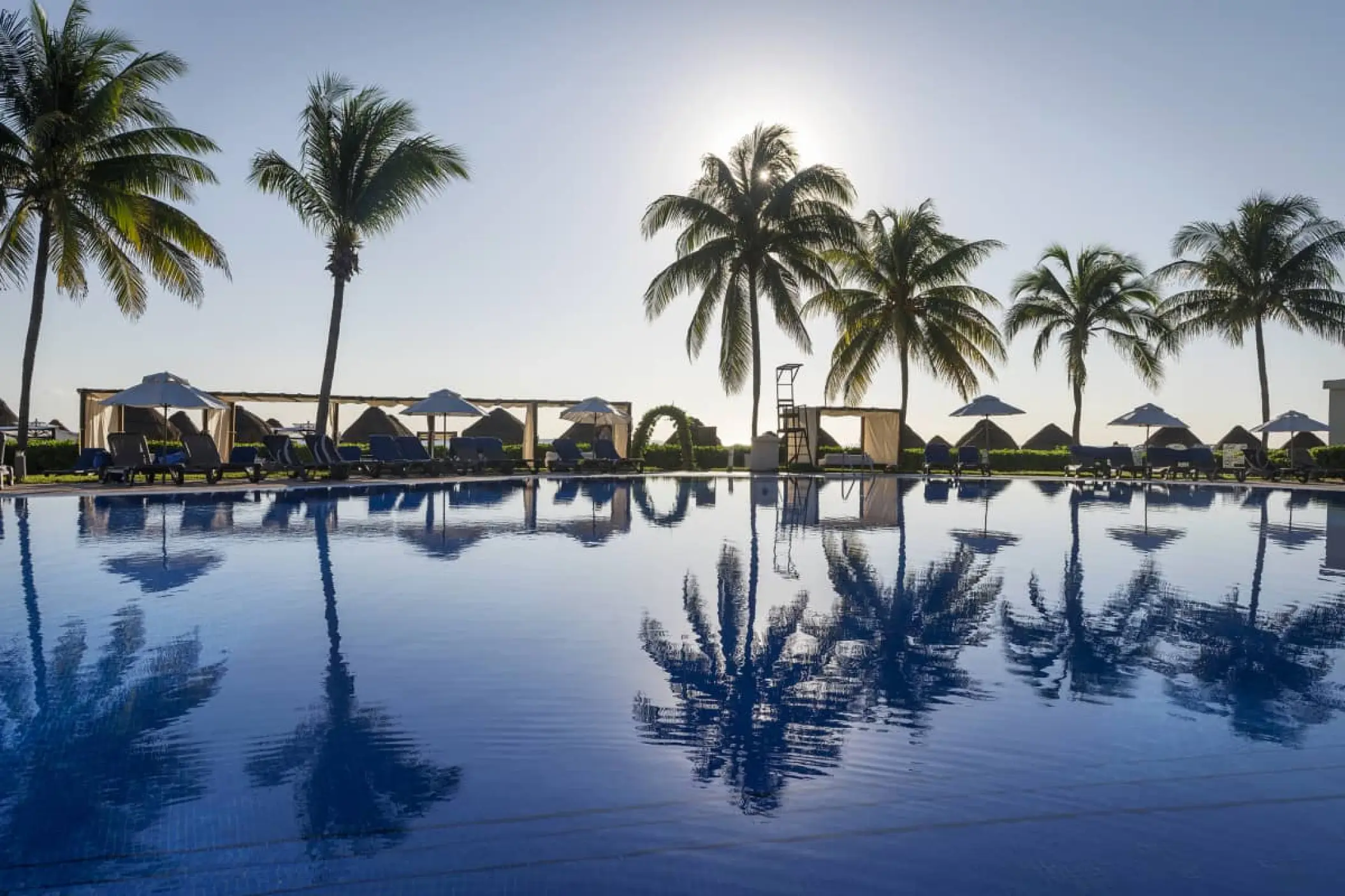 Palm trees reflecting in the main swimming pool at Ocean Coral & Turquesa, Riviera Maya