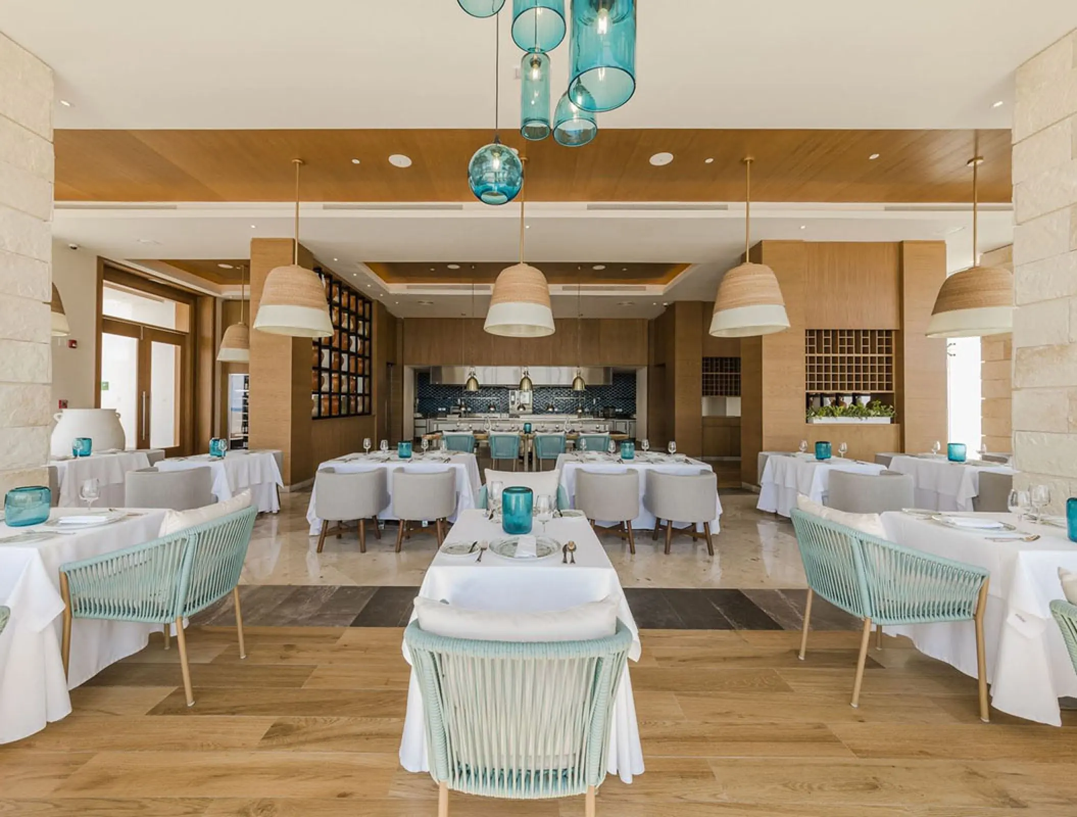Olios restaurant dining room with blue accents at Haven Riviera Cancun, Riviera Maya