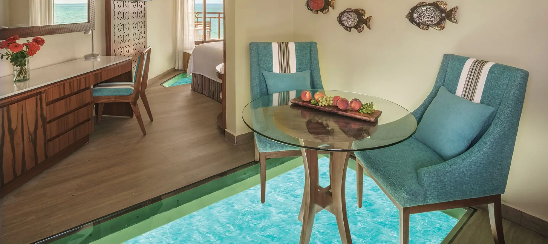 Overwater bungalow suite with a glass floor dining area at El Dorado Palafitos, Riviera Maya