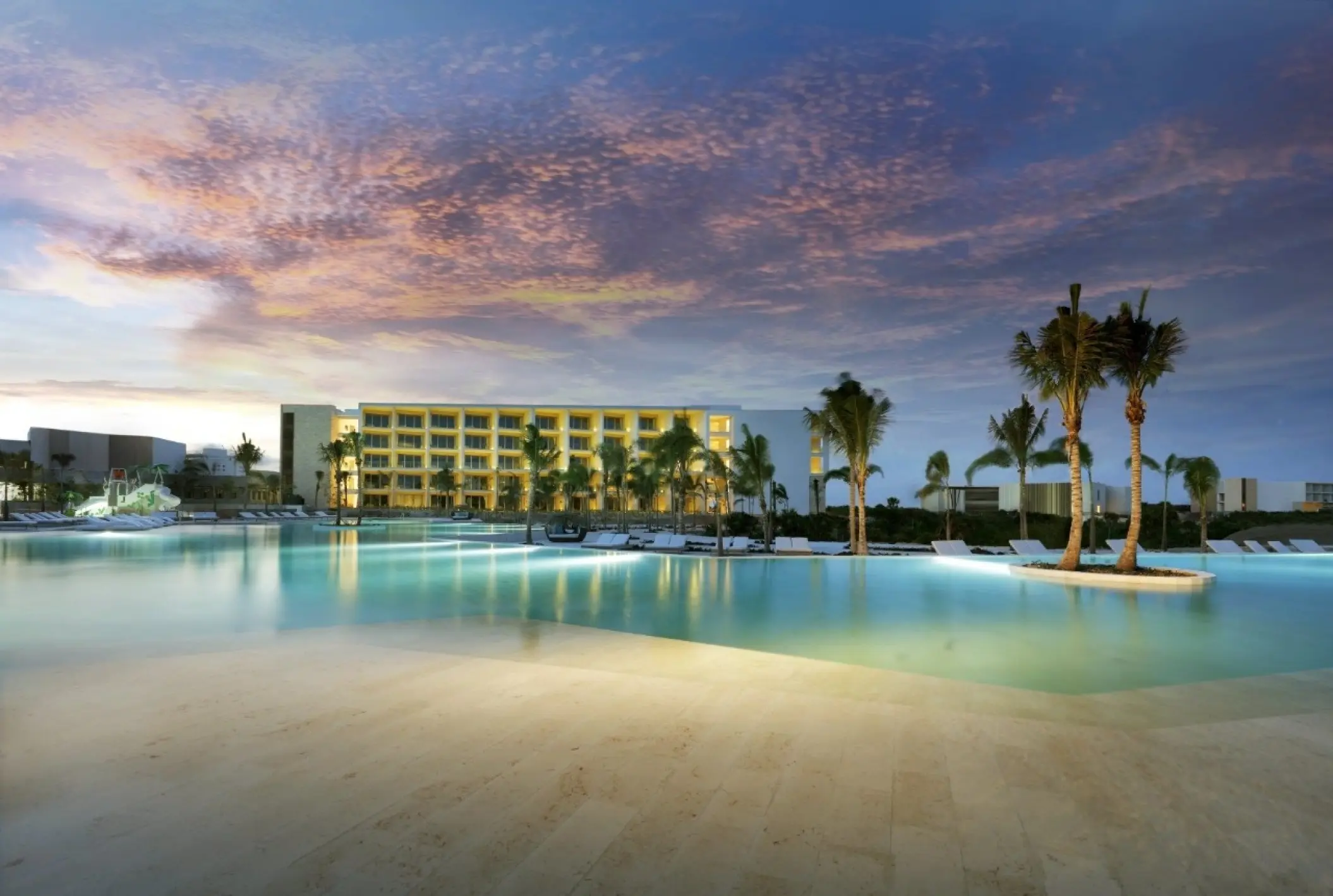 Grand Palladium Costa Mujeres swimming pool and palm trees at sunset, Cancun