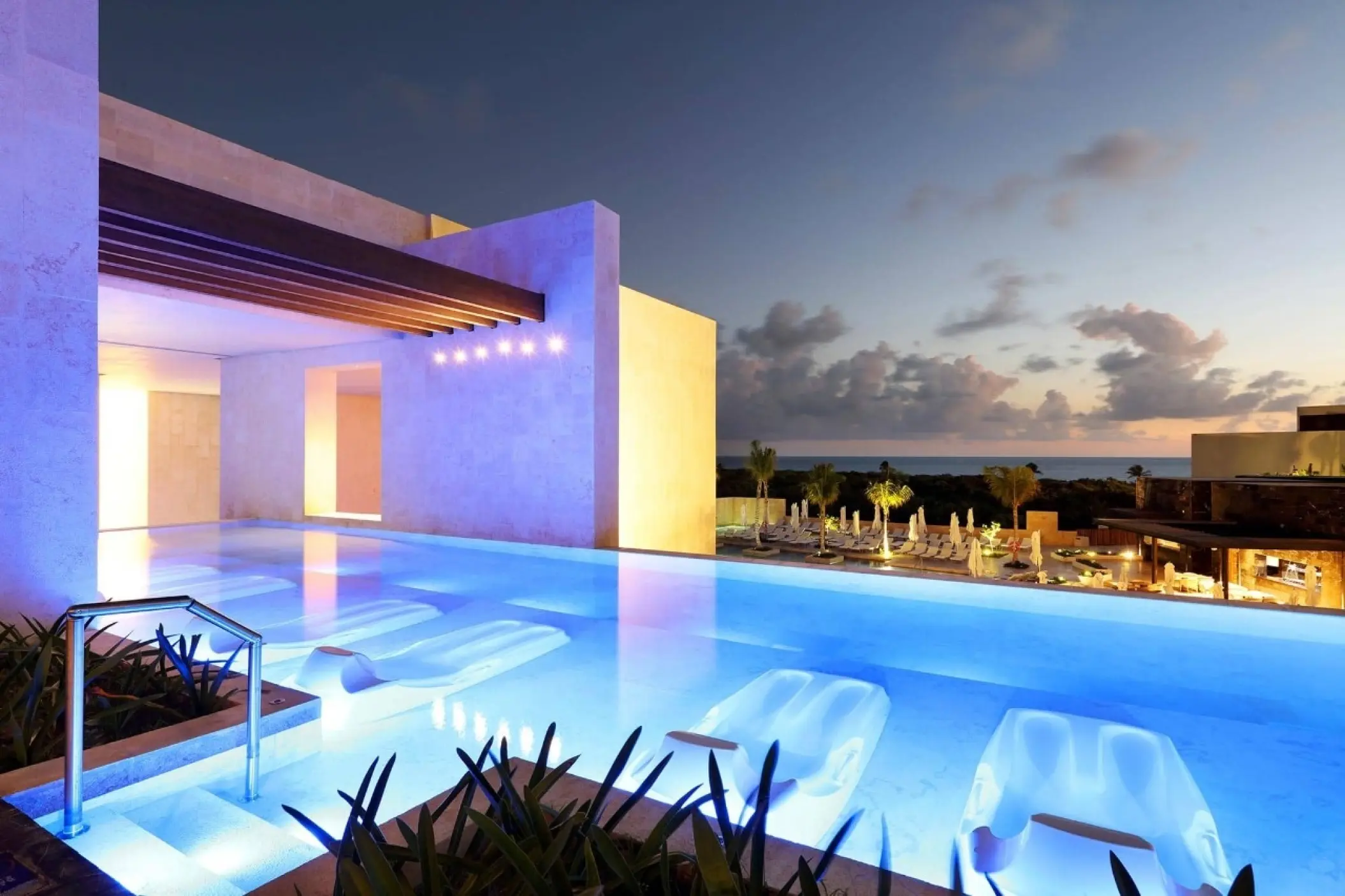 Illuminated infinity pool with in-water loungers at Grand Palladium Costa Mujeres, Cancun