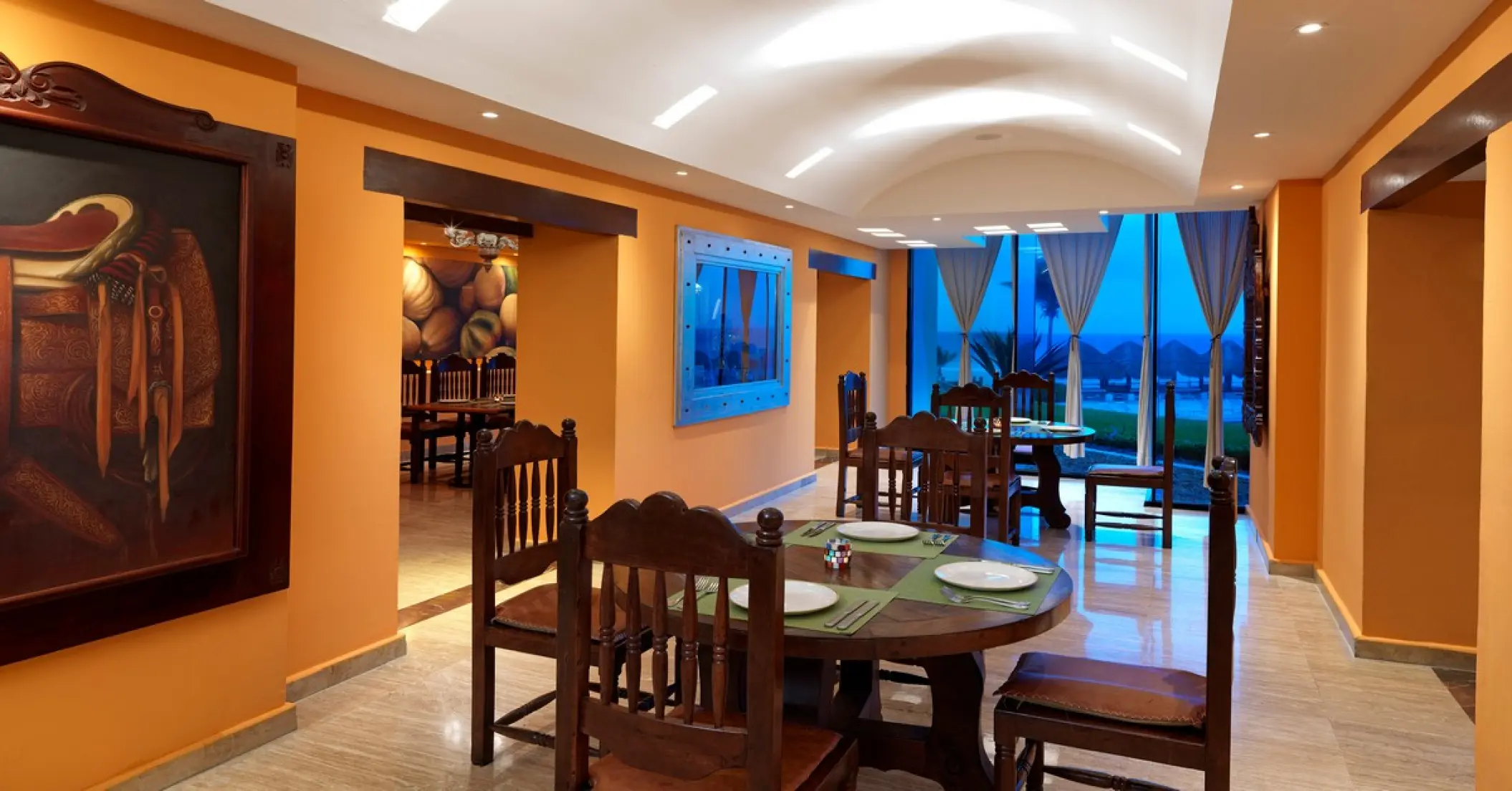 Cielo restaurant dining area with wooden tables and orange walls at Paradisus Cancun