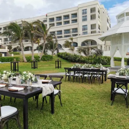 Garden wedding reception with dark wood tables and white gazebo at Paradisus Cancun