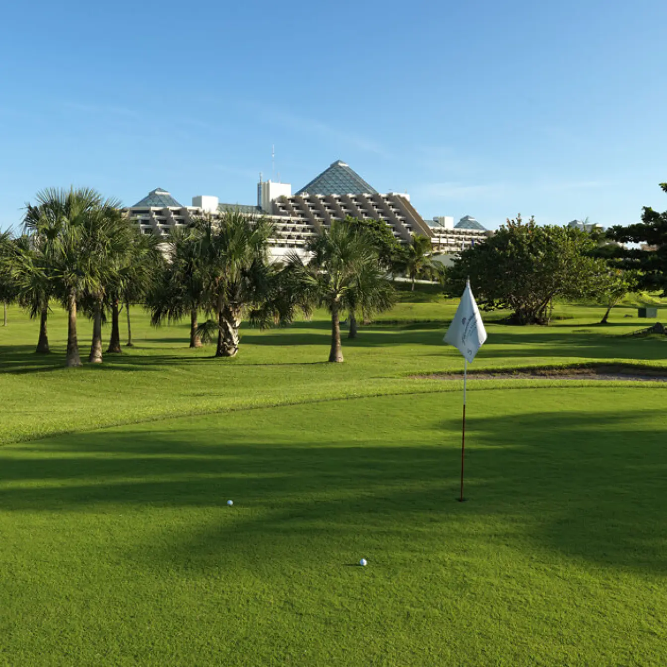 Green golf course with palm trees at Paradisus Cancun, Cancun