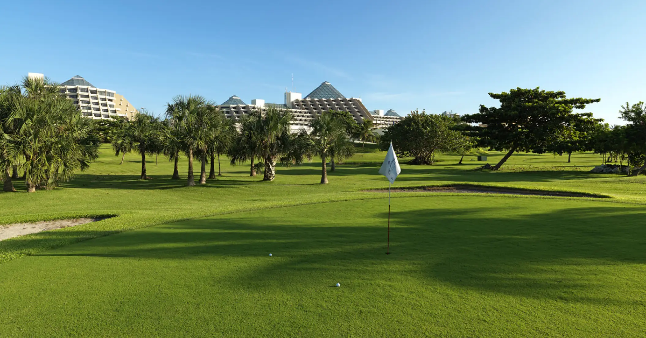 Green golf course with palm trees at Paradisus Cancun, Cancun