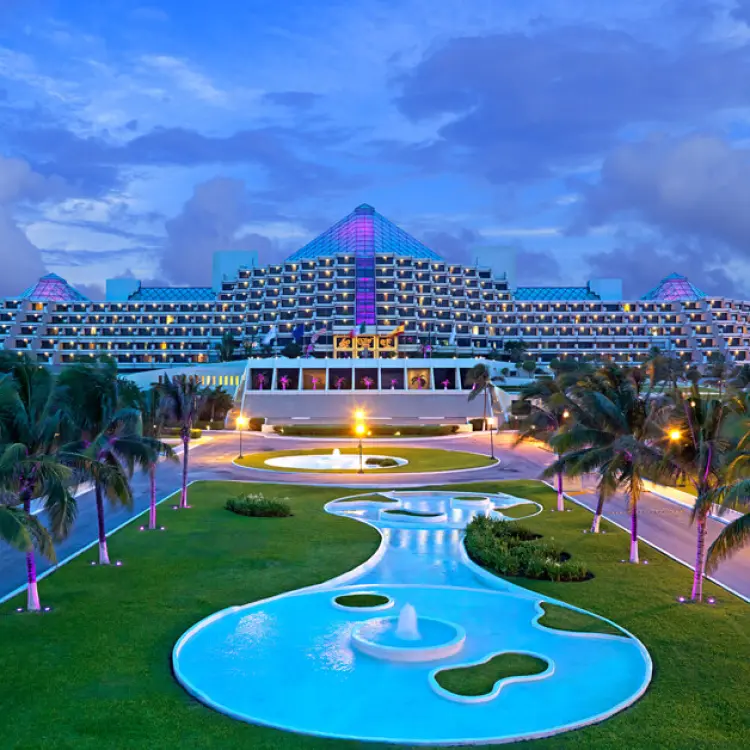 Paradisus Cancun pyramid-style buildings and illuminated pool area at dusk, Cancun