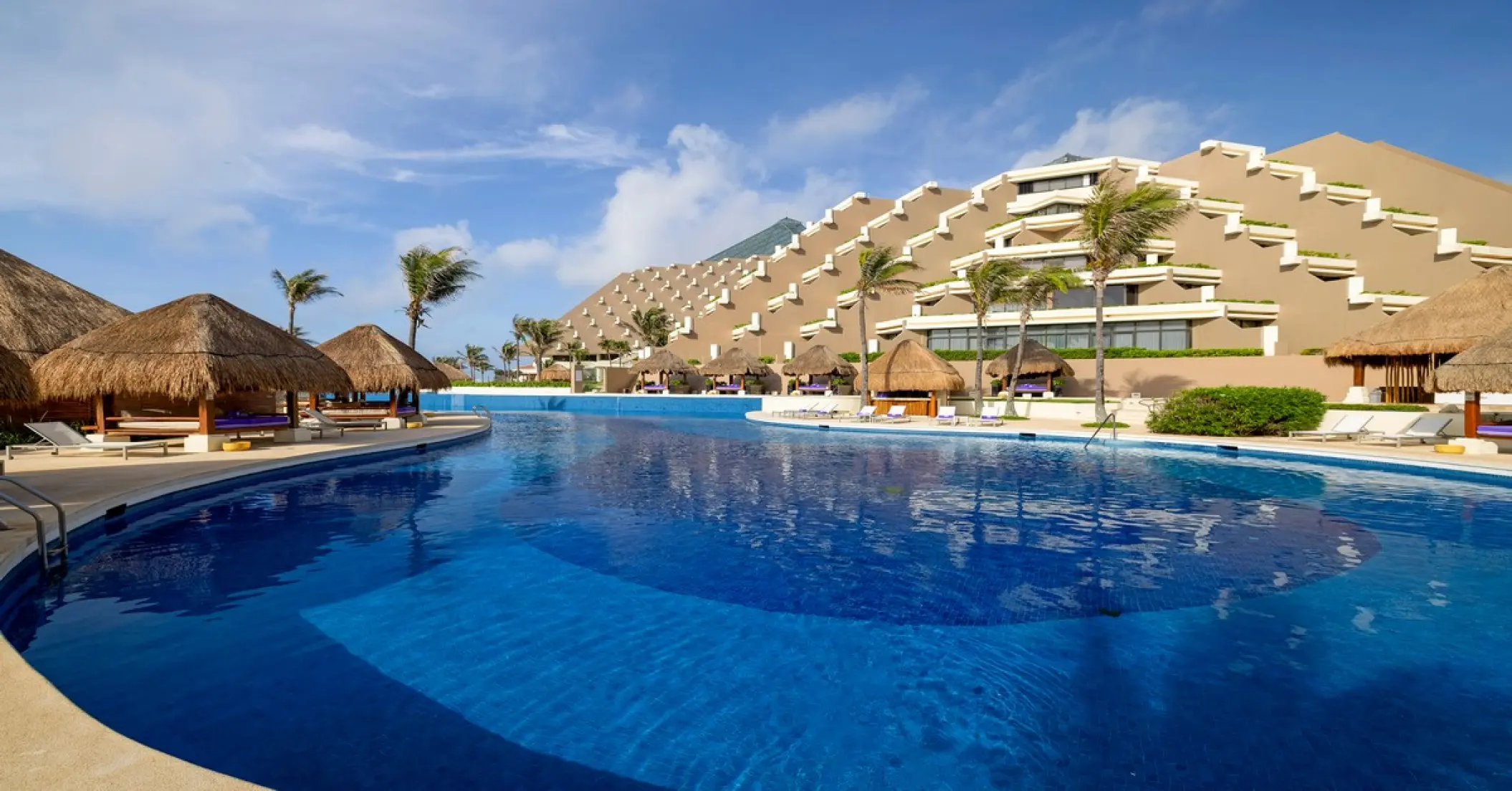Adults-only pool with palapas and tiered pyramid architecture at Paradisus Cancun